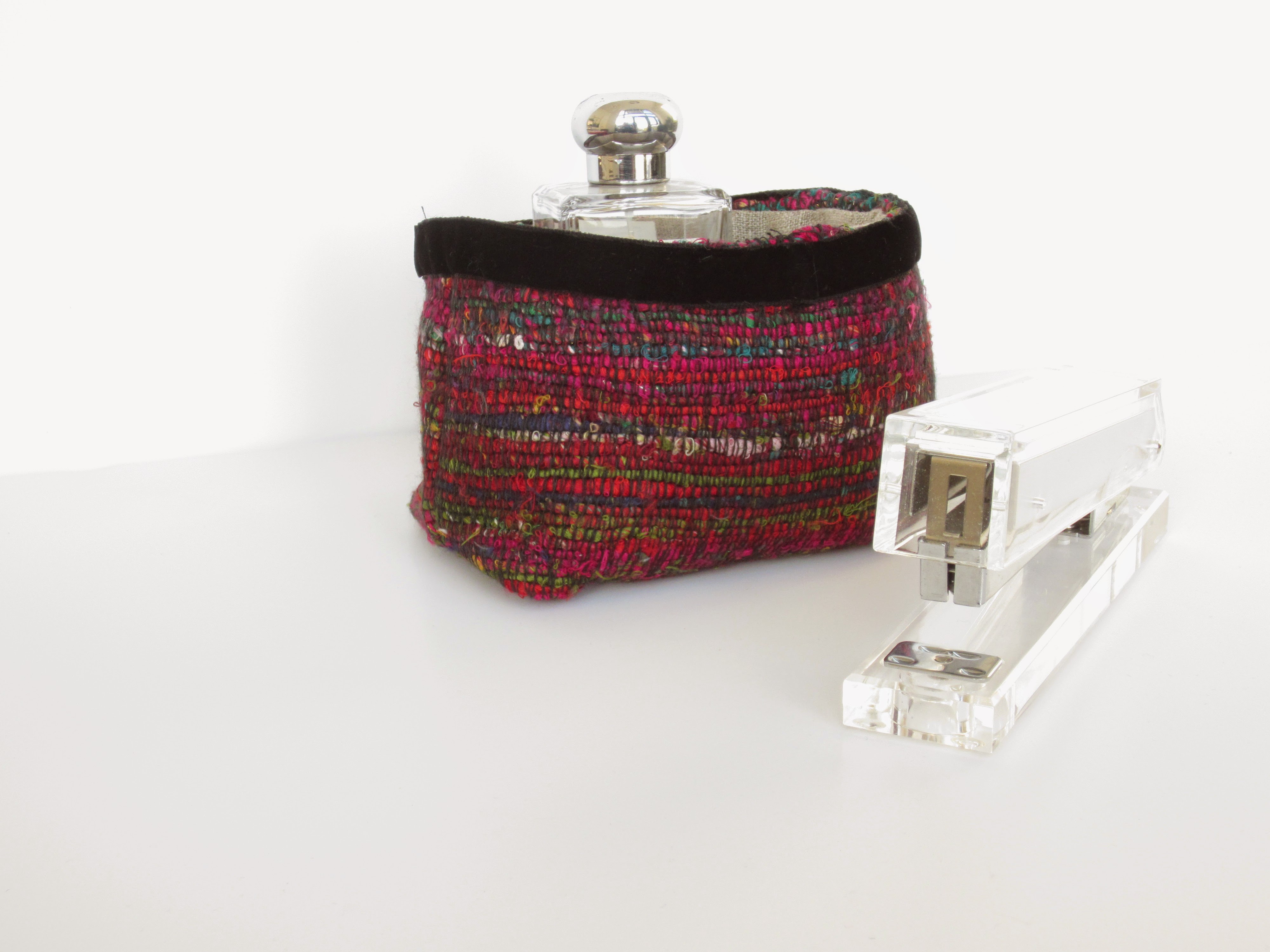 Red fabric basket against white background.