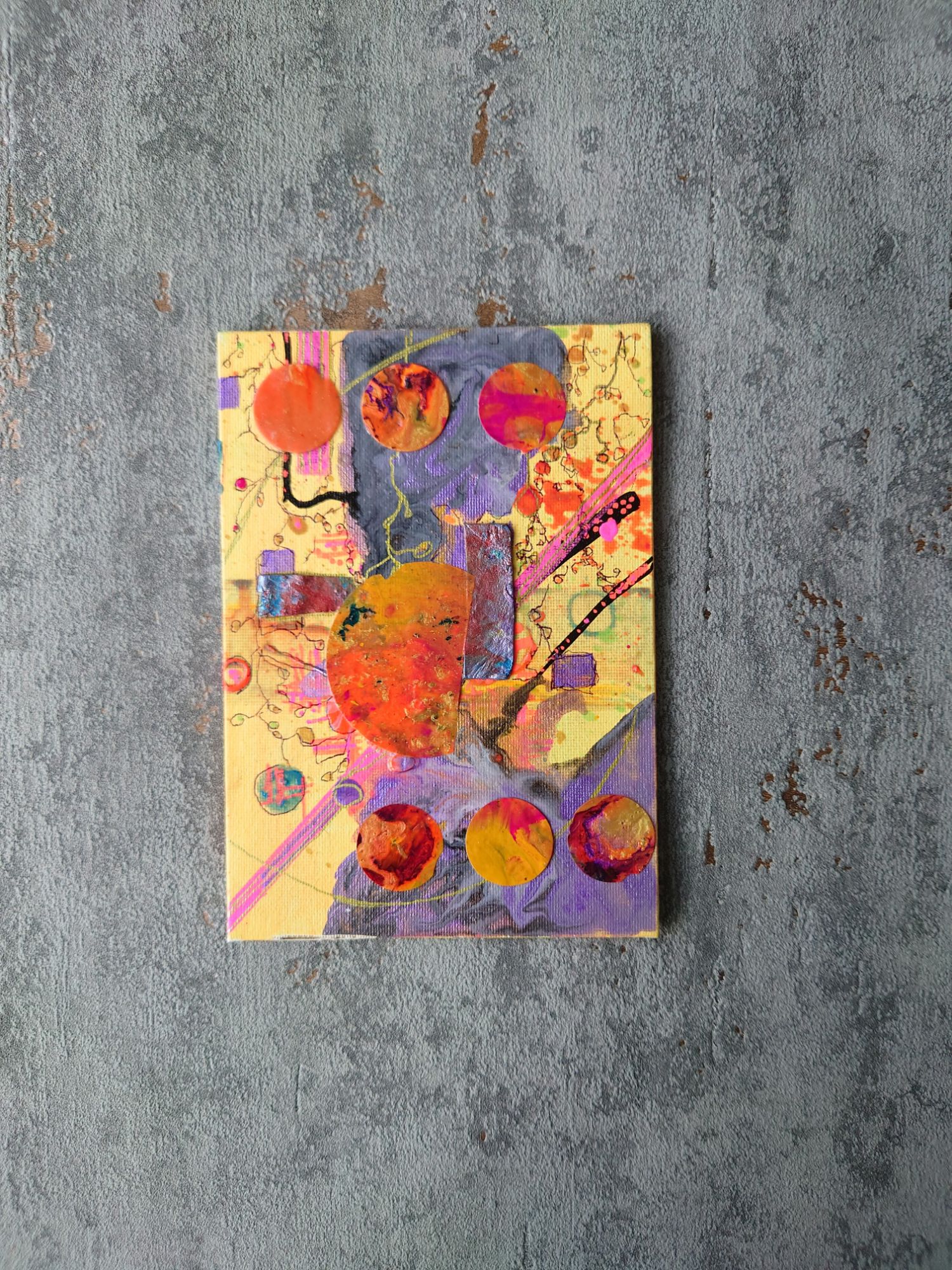 Bright cannery yellow painting on a wide grey concrete texture border. Painting has purple, lavender, pink and orange elements. 
