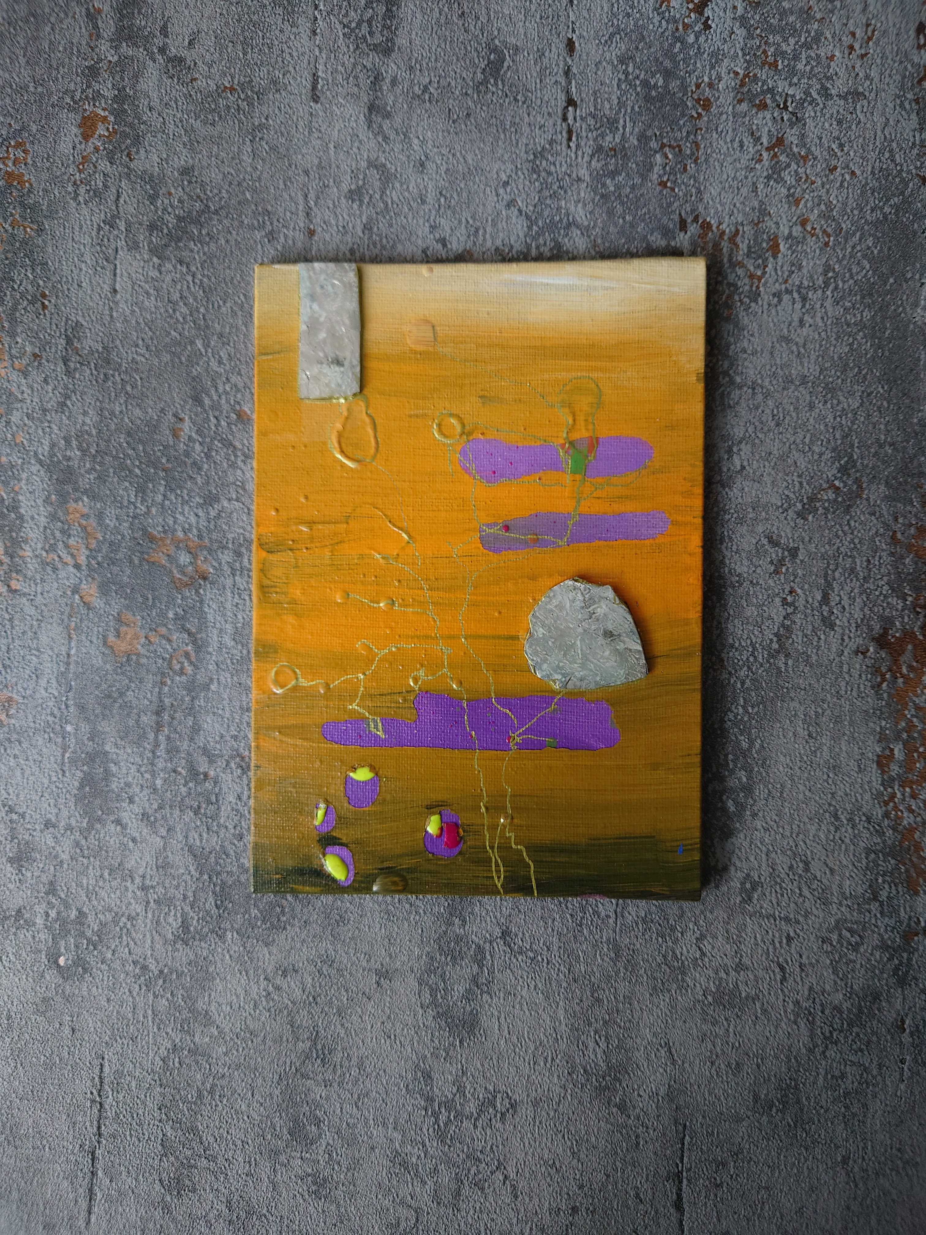 Mustard yellow mixed media painting on a grey concrete texture border. Painting has grey marbled elements 