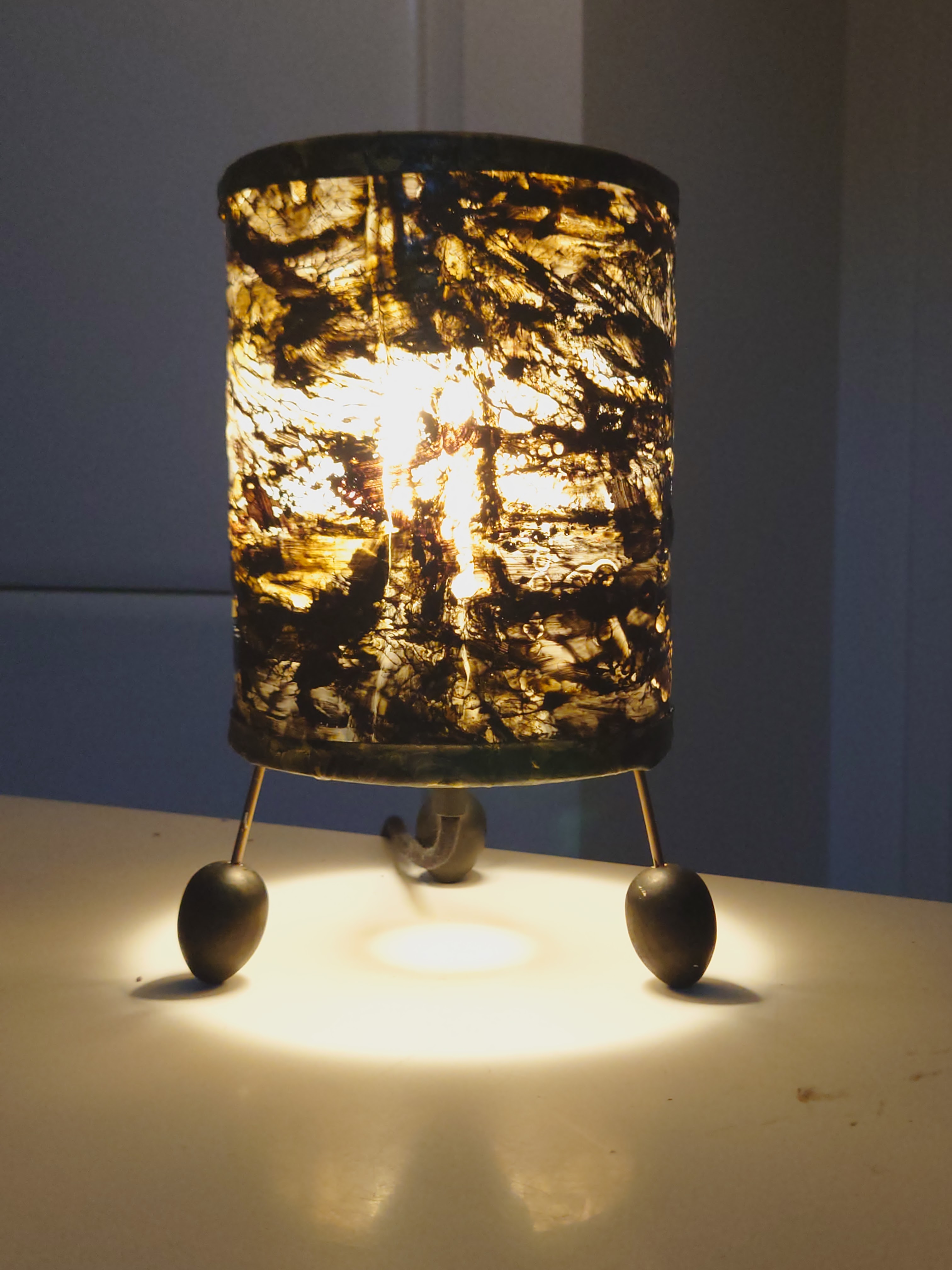 Three new kinds of lighting in black and gold. images show close up of each piece including the electrical fittings. Three lights are displayed on a shelf with the lights switched on to show a golden glow. 