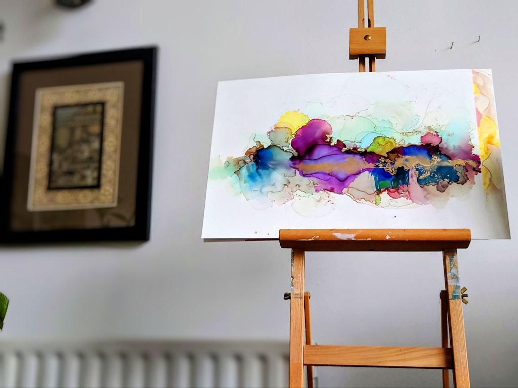 A gallery of four abstract paintings with bright bold colours